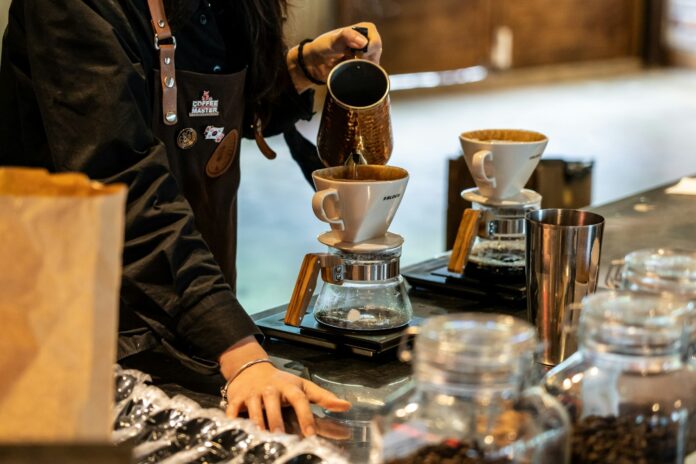Barista preparând cafea filtru la tejgheaua unei cafenele de specialitate