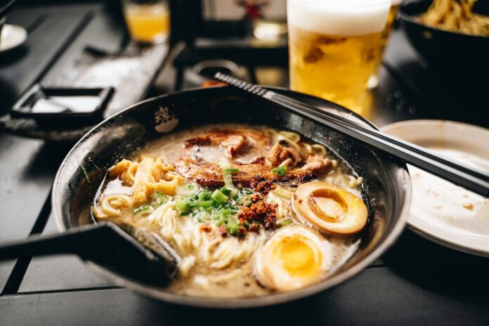 Bol de ramen cu carne de porc, ou marinat și ceapă verde, cu bețișoare