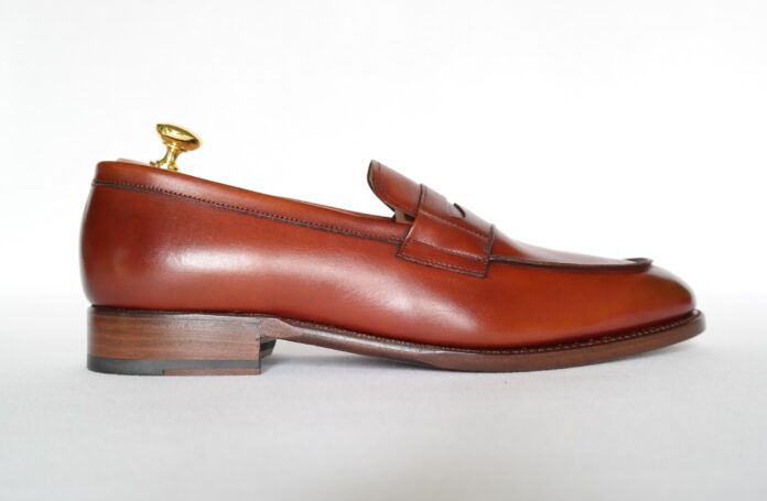 Mocasin maro din piele, de tip penny loafer, văzut din lateral